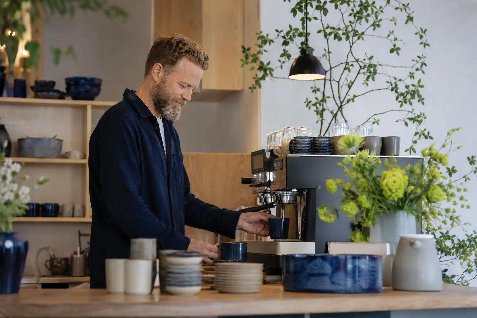 Café owner behind the counter in a bright Scandinavian bakery